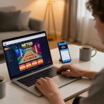 Engaging in online gaming at NET88 with a laptop and smartphone setup, showcasing modern gambling.