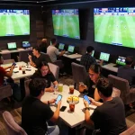 Experience the excitement of live sports betting with Nowgoal app on smartphones in lively lounge