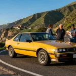 Classic 1988 Holden HSV SV88 parked on a scenic coastal road with car enthusiasts discussing its features.